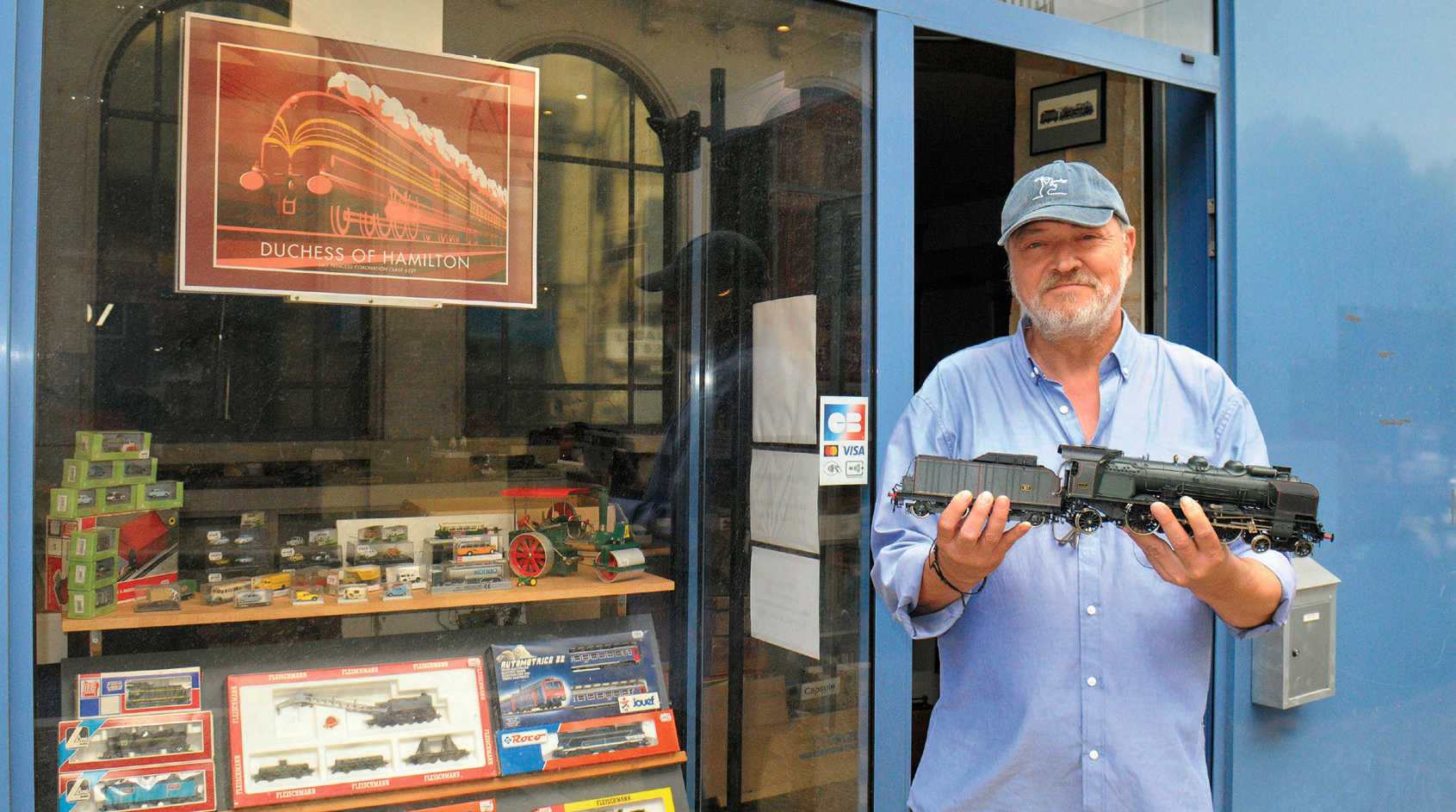 Stéphane Orliac devant son magasin à Périgueux, avec une LGB à échelle 1/22,5e, une des marques pionnières de trains de jardin.