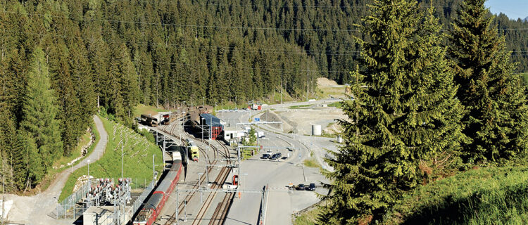 Depuis le portail du tunnel de la Vereina, vue sur le terminal de Klosters-Selfranga. Le train de voyageurs visible vient de quitter le tunnel de Zugwald et va disparaître dans celui de la Vereina (Bernhard Studer ; 11 juin 2006).