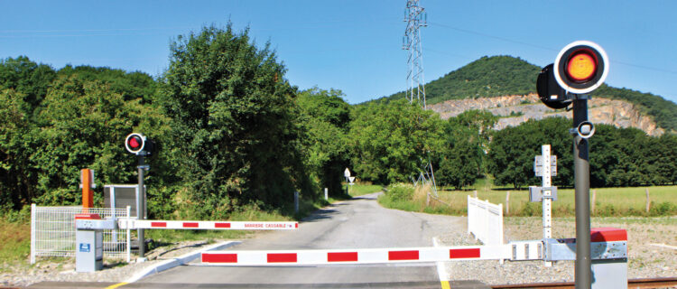 Le PN Flex en position fermée avec clignotement des signaux lumineux, ici le PN n° 2 de Montréjeau - Luchon. Le haut-parleur situé sur le mât diffuse le fichier son reproduisant la sonnerie des PN SNCF (19 juin 2025)