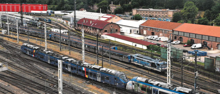 freiÉvolution dans l’avant-gare nord de Strasbourg d’un couplage 85500 + 84500. En arrière-plan, le diesel 67596 au garage de Gare-Basse, en tête d’une RRR, sert de réserve secours en cas de défaillance d’éléments automoteurs (27 juin 2025 ; B. Collardey).