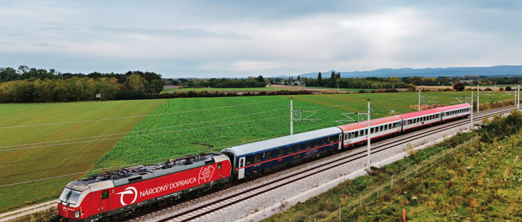 Le train REX 8 2523, assuré par une rame de quatre voitures ÖBB, dont une voiture Nightjet places assises, remorquée par la Vectron MS 383 001-3 louée par les ZSSK à Rolling Stock Lease, vient de quitter Marchegg où a eu l’échange de personnel ZSSK/ÖBB (14 octobre 2025).
