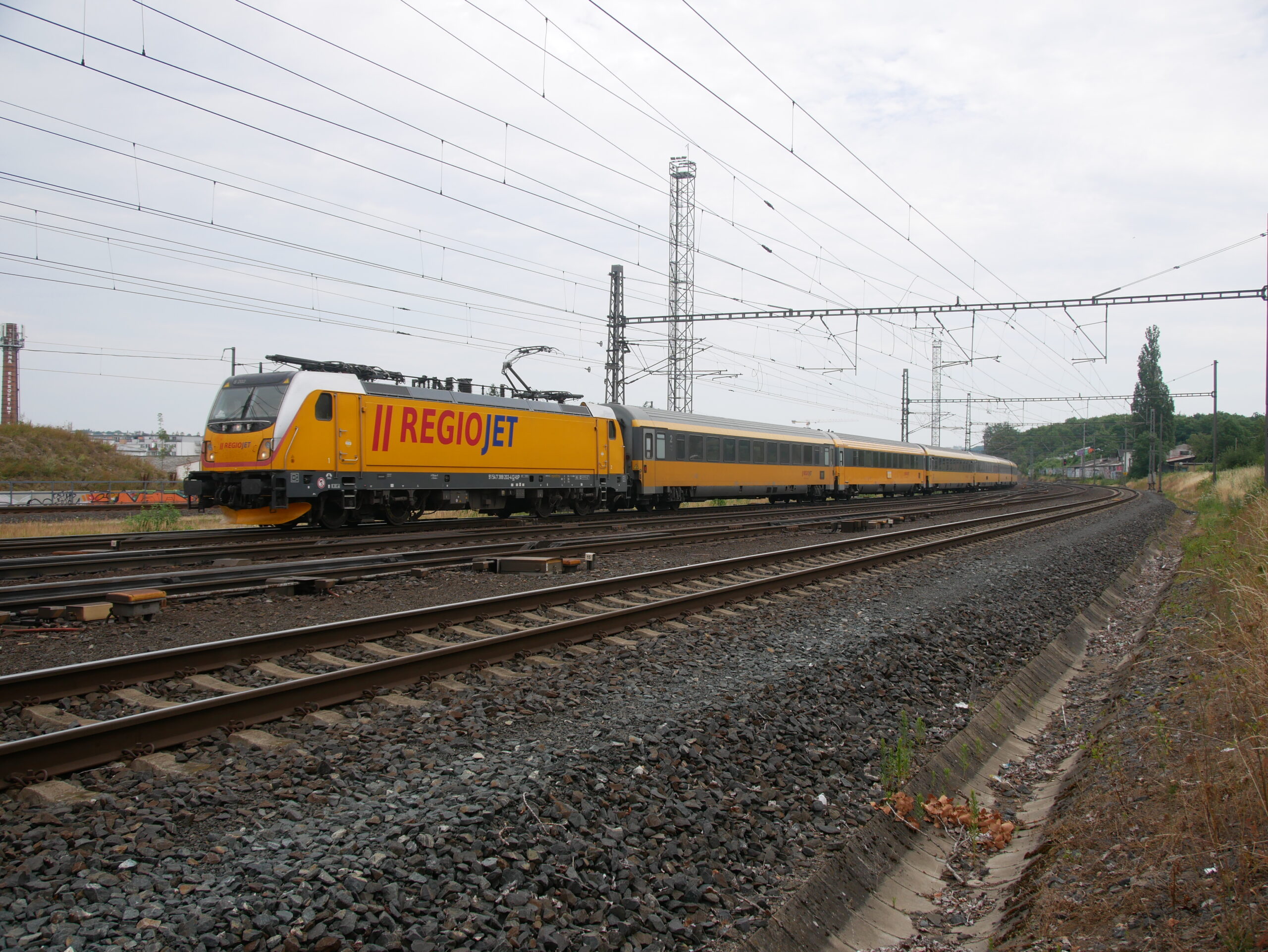 Pologne : RegioJet arrête l’exploitation de trains en open access en Pologne 1 2310076 : Le train RJ 1008 Košice – Prague-Zaradní Město, remorqué par la Traxx 388 202-4 de RegioJet Pool, traverse la gare de Prague-Libeň (21 juillet 2025) Crédit photo : Luc LEVERT