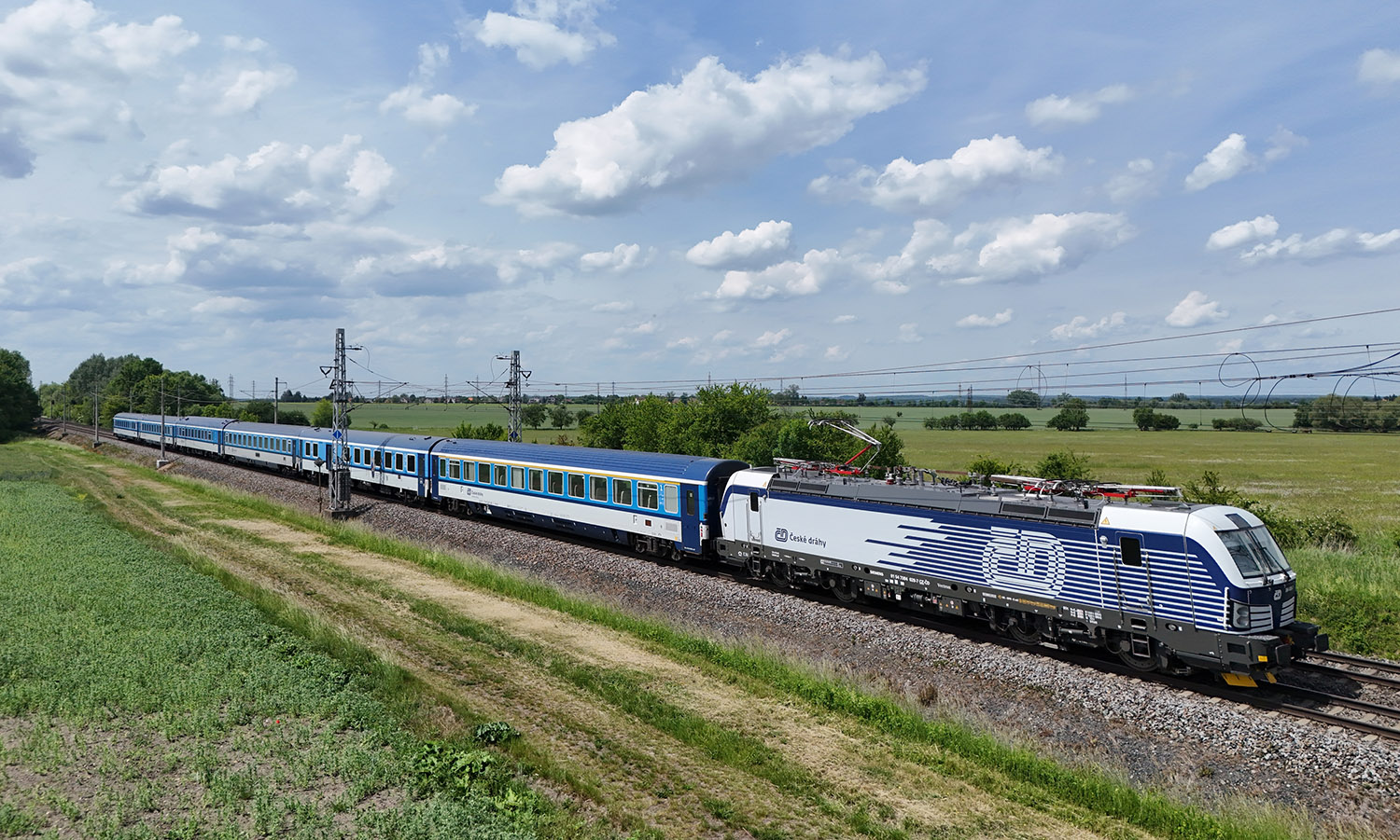 République tchèque : Les 50 Vectron 230 toutes livrées aux ČD 2 DJI 016 : Le train Slovácký expres R 891 Praha Vršovice – Staré Město u Uherského Hradiště, remorqué par la Vectron 230 384 028-7, est aperçu peu avant la gare de Pardubice-Opočinek (2 juin 2026). Crédit photo : Luc LEVERT