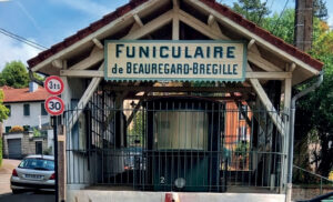 A Besançon, la gare de Beauregard-Brégille, située en haut, offre une vue à 180 degrés sur la ville et ses alentours. Derrière la grille, une motrice d’origine du funiculaire. (© Alain Masson)