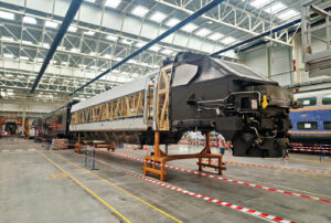 Caisse de motrice TGV ex-R/D en cours de traitement corrosion après décapage et avant peinture pour devenir une motrice TGV R inOui. En arrière-plan, présence d’une caisse de TER 2N NG et d’une caisse d’AGC en opération mi-vie (14 juin 2025 ; M. Remond).