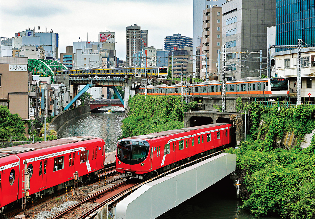 À Tokyo, entre les stations Ochanomizu et Awajichō de la ligne Marunouchi, les nouvelles rames de métro à six voitures de la série 2000, mises en service en 2019, traversent le viaduc au-dessus de la rivière Kanda alors que deux trains de banlieue de JR East arrivent à la gare d’Ochanomizu (à droite de la photo). Celui avec une bande jaune appartient à la série E231-500 de la ligne Chūō-Sōbu, celui avec une bande orange à la série E233 de la ligne Chūō (Rapide) (B. Kogut).