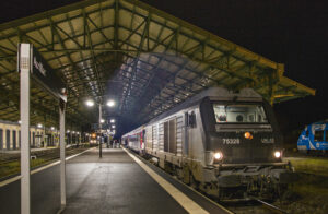 Paris - Aurillac : un train de nuit fantôme… 13 Sous la marquise d'Aurillac, le train 3790 à destination de Paris-Austerlitz est prêt au départ. Il sera tracté jusqu'à Brive-la-Gaillarde par la BB 75738, et traîné par son ancienne livrée Lines révèle aussi ses anciennes missions en tête de convois de marchandises (26 février 2025).
